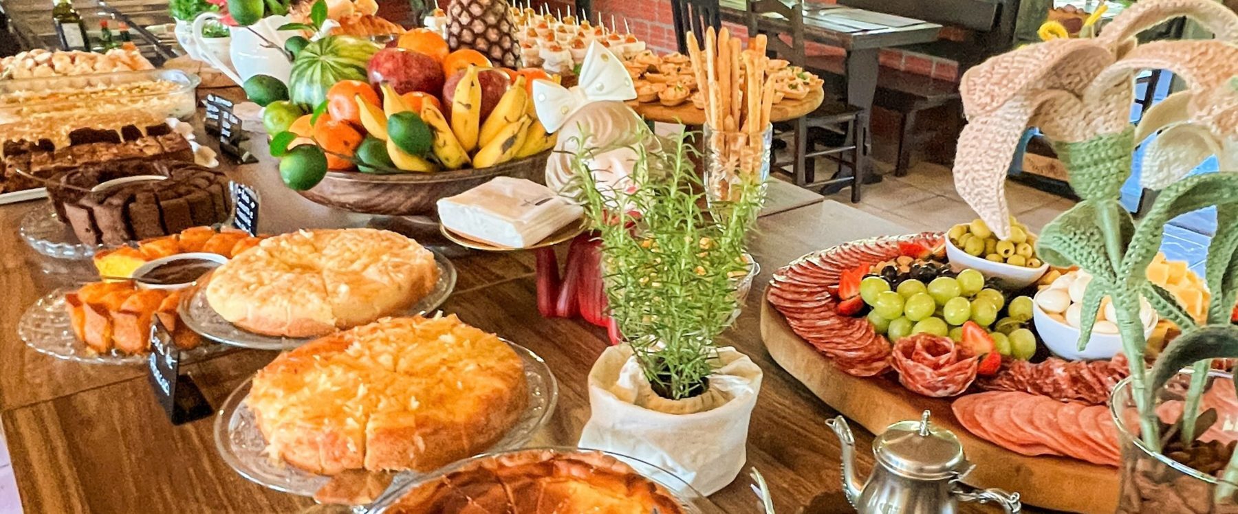 Mesa do café colonial com tortas, frutas e frios